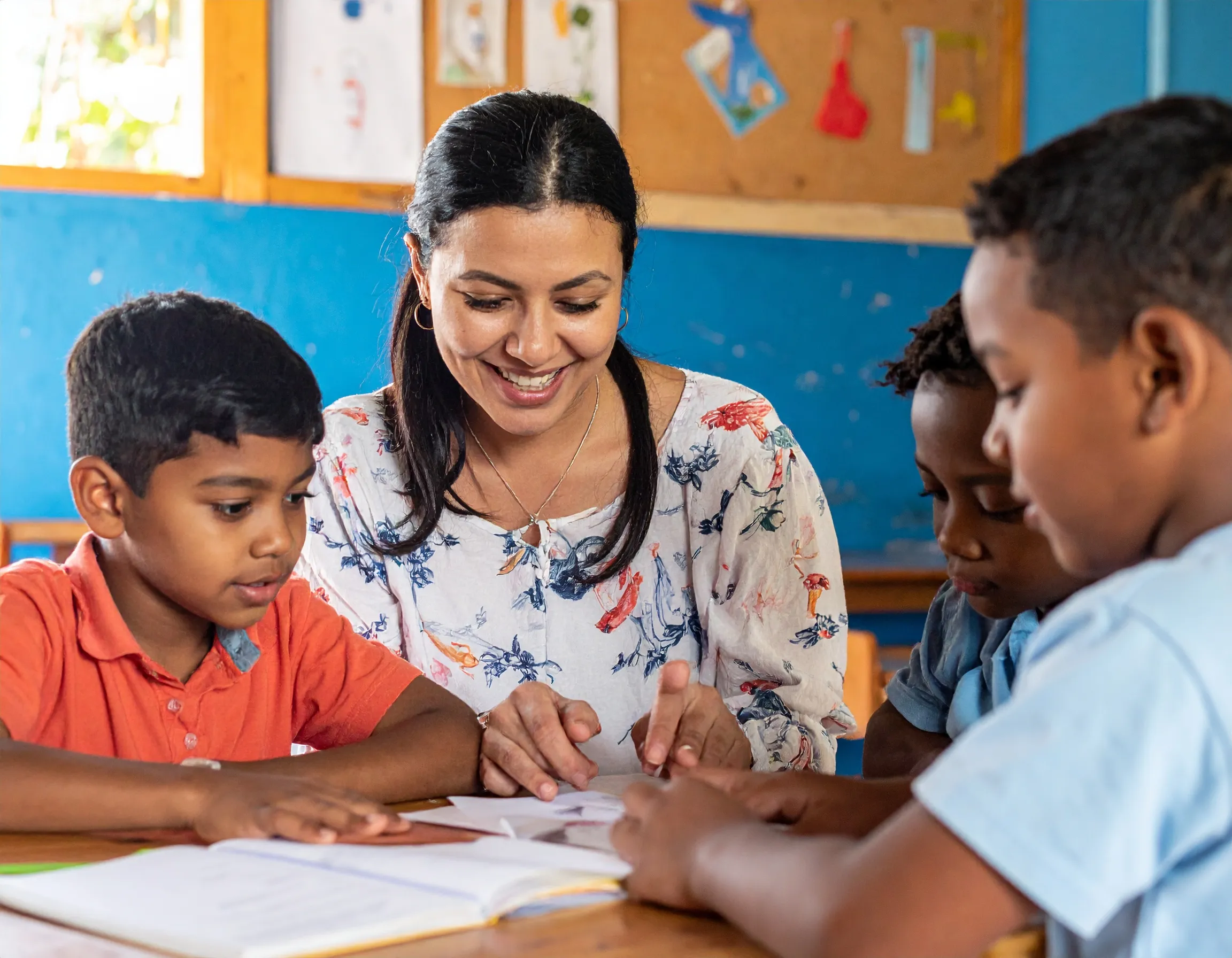 Educadora auxiliando uma criança em sala